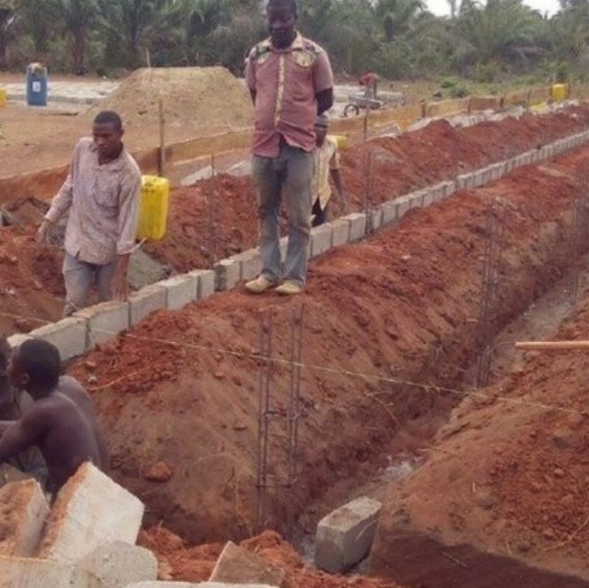 Workers laying the foundations of a school