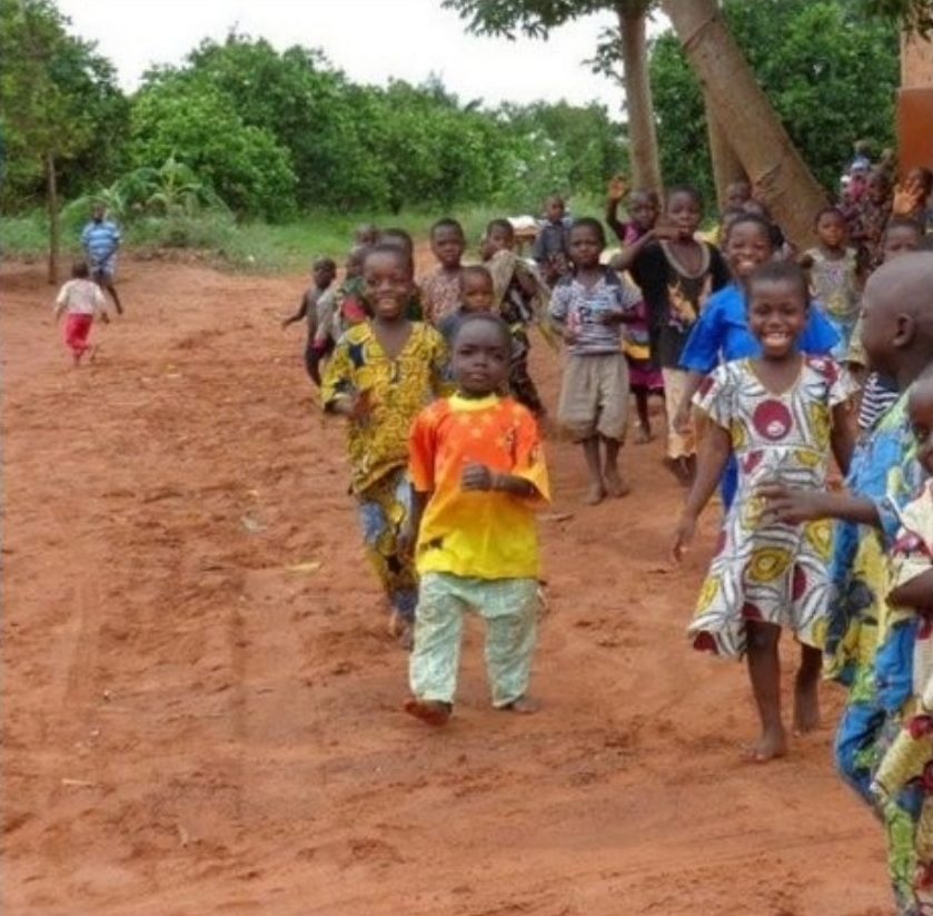 Children walking along a red earth road